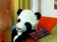 Skinny blonde teen Sveta with natural boobs and pretty face takes off hot pants and plays with gigantic black dildo while riding on her full size panda doll in kinky fantasy.