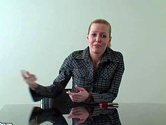 Cute and shy looking blonde babe in dark shirt gives an interview at the desk before her first porn audition and showing all of her talents to the cam