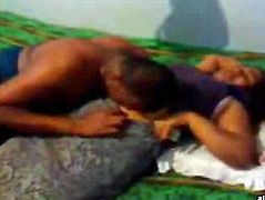 Indian couple sitting on the bed kissing