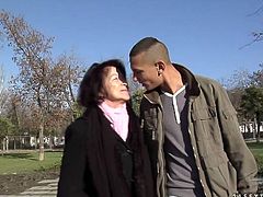 Whorish brunette mom picks up a sex hungry young dude in the street. They head to the park where they kiss with passion sitting on the bench before she lures him home.