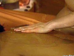 This cute masseuse rubs a hottie's body with oil and then she focuses on massaging her pussy using a special technique.