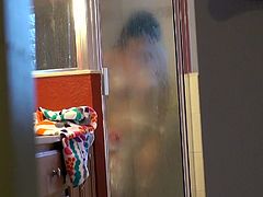 You are going to have a slight glance at the girl soaping her sexy body in the bathroom. The silhouette of her body is observable through the glass door of the shower cabin.