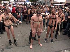 He's a very pretty boy and luckily, the guys have blindfolded him, so he won't see that crowd, that's staring at him. The sexy gay is completely naked and tied with rope, as his friends give the crowd an interesting show, using his hot body.