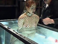 Calico is put underwater by her master and he locked her up, shackles her arms and legs, and wraps a net around her. She is dropped into a large tank, where she gasps. He lets her up for some air, but then put her under water again.