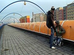 This European bitch pees by the railway and takes cock from behind while two people passing by film her. Then, they move to another place where she blows him and gets fucked again.
