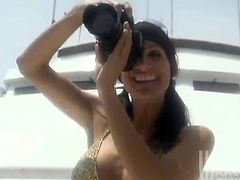 Stunning Stormy Daniels poses for the photo camera on the yacht. Then she takes a bikini off and starts to toy her bald pussy.