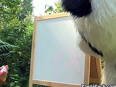 Young and sexy brunette tries to make a painting as a huge toy bear shows up by her side and has a wild strap on sex outdoor.