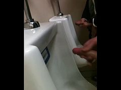 two slim dicks getting wanked at the urinals