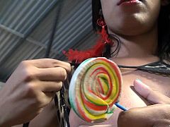This sensual dark haired tranny slut has a gigantic candy and she plays with it wonderfully. She looks so hot as she sucks it. She rubs the candy against her crotch and nipples. She pulls her cock out and jacks off.