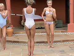 These three blonde teens with slim bodies exercise in bathing suits before they get naked. Next, they pour oil on their bare bodies and touch each other all over.