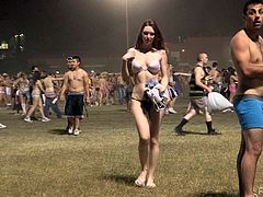 Beautiful brown-haired chick Meghan is having fun outdoors. She walks down the field in her thong and bra and doesn't mind a lot of people to watch her.