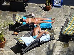 two hot girls poolside in waikiki taking their tops off