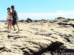 Go wild as you watch this Japanese cougar, with big knockers wearing a red thong, while she goes hardcore outdoors behind some rocks.
