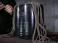 This master loves to torture and humiliate her slave. She is locked in a chair which restrains her and she has a bucket put on her head. The bucket has a face drawn on it. She uses a vibrator on her cunt, which makes the slaves toes curl up.