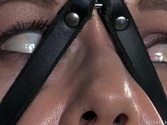 This slave girls gets pounded hard by a dildo on a metal pole. She is is locked in restraints with straps around her legs, face and body. The master cruelly dominates her and she can't scream because she has a ball gag in her mouth. As her nipples as pinched her eyes roll back into her head.