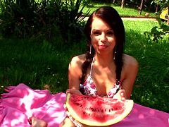 Kiki is out in the backyard laying around completely naked. She has a big piece of water melon that she is going to eat for lunch. The cute teen eats it seductively and the juices roll down her cute body. She is horny so she flicks her clit.