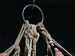 He is tied up tightly in rope. The rope around his neck is so tight he is choking as gasping for air. His master whips the bottom of his feet. One of the dominant master's shoves his cock in the gay slave's mouth, the other shoves his cock in that tight asshole.