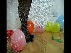 Watch as this busty slut in stockings and heels bursts these balloons