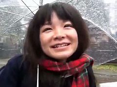 This Japanese schoolgirl has a toy in her panties. She walks through a cemetery and flashes her panties and the vibrator that stimulates her pussy while holding an umbrella.