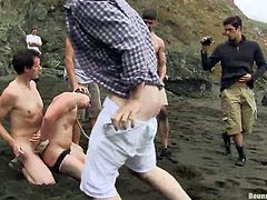 A blindfolded guy has to crawl on the sandy shore, following obediently his dominant master. While the bounded man is persuaded into sucking cock, another angry boy fucks him awfully from behind. A curios crowd gathers to witness the kinky scenes. Enjoy the view!