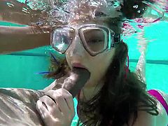 This cute teen is with her boyfriend in the swimming area. She puts on mask for diving, to suck his cock underwater. It looks like she has been caught by the milf, so now the sexy older woman is going to show this teen the proper way to suck cock.