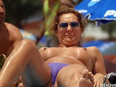 Topless milf gets some sun in the sand