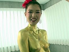 Check out this Asian girl completely painted gold. She dazzles us with her body and cute smile. The hottie winks at the camera and timidly kneels in front of her man's penis to suck him off. The gold queen works the shaft, while using her lips on the head.