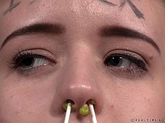 Jessica is in a steel drum, with only her head visible. Her mistress shoves her fist in her mouth, puts q-tips up her nose and leaves them there, writes on her head, and even puts rat traps on her ears. She must have been really bad.