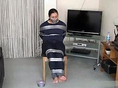 Barefoot girl tied to chair