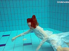 Sweet looking red haired hottie Diana Zelenkina is stripping under the water