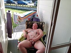 Fat man masturbates by a public road.