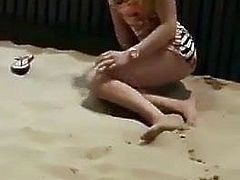 Blonde masturbating in the beach with people