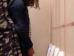 Long haired guy pissing at urinals
