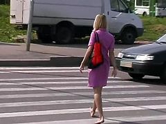 Beautiful blonde walking barefoot in town.