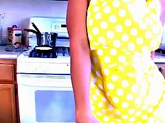 A huge-chested woman in a yellow peruke uses a fake penis